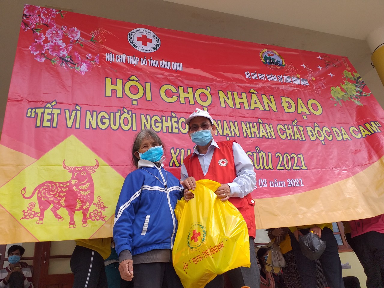 Ông Hà Văn Cát - Ủy viên Ban Thường vụ Hội CTĐ Việt Nam, Chủ tịch Hội CTĐ tỉnh trao tặng quà Tết tại phiên chợ Nhân đạo cho đồng bào xã Miền núi An Dũng