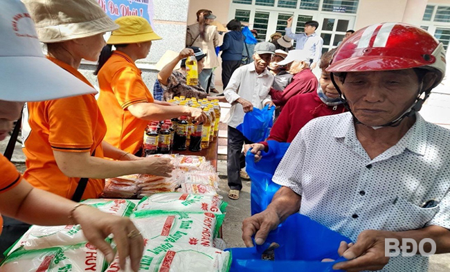 Tặng quà cho các hộ nghèo, có hoàn cảnh khó khăn. Ảnh: XUÂN THẮM