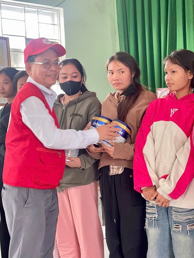 Ông Hà Văn Cát - Chủ tịch Hội CTĐ tỉnh Bình Định trao sữa cho phụ huynh khu phố Hiệp Giao