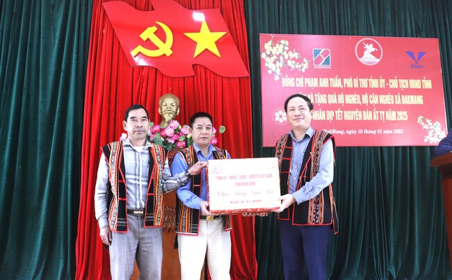 Chủ tịch UBND tỉnh Phạm Anh Tuấn (bên phải) tặng quà tết cho Đảng bộ, chính quyền xã Đak Mang (huyện Hoài Ân). Ảnh: M.H