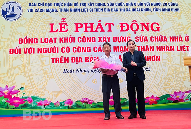 Đồng chí Hồ Quốc Dũng - Ủy viên Trung ương Đảng, Bí thư Tỉnh ủy, Chủ tịch HĐND tỉnh tặng hoa, bảng tượng trưng cho thương binh Võ Văn Cư. Ảnh: Thái Ngân