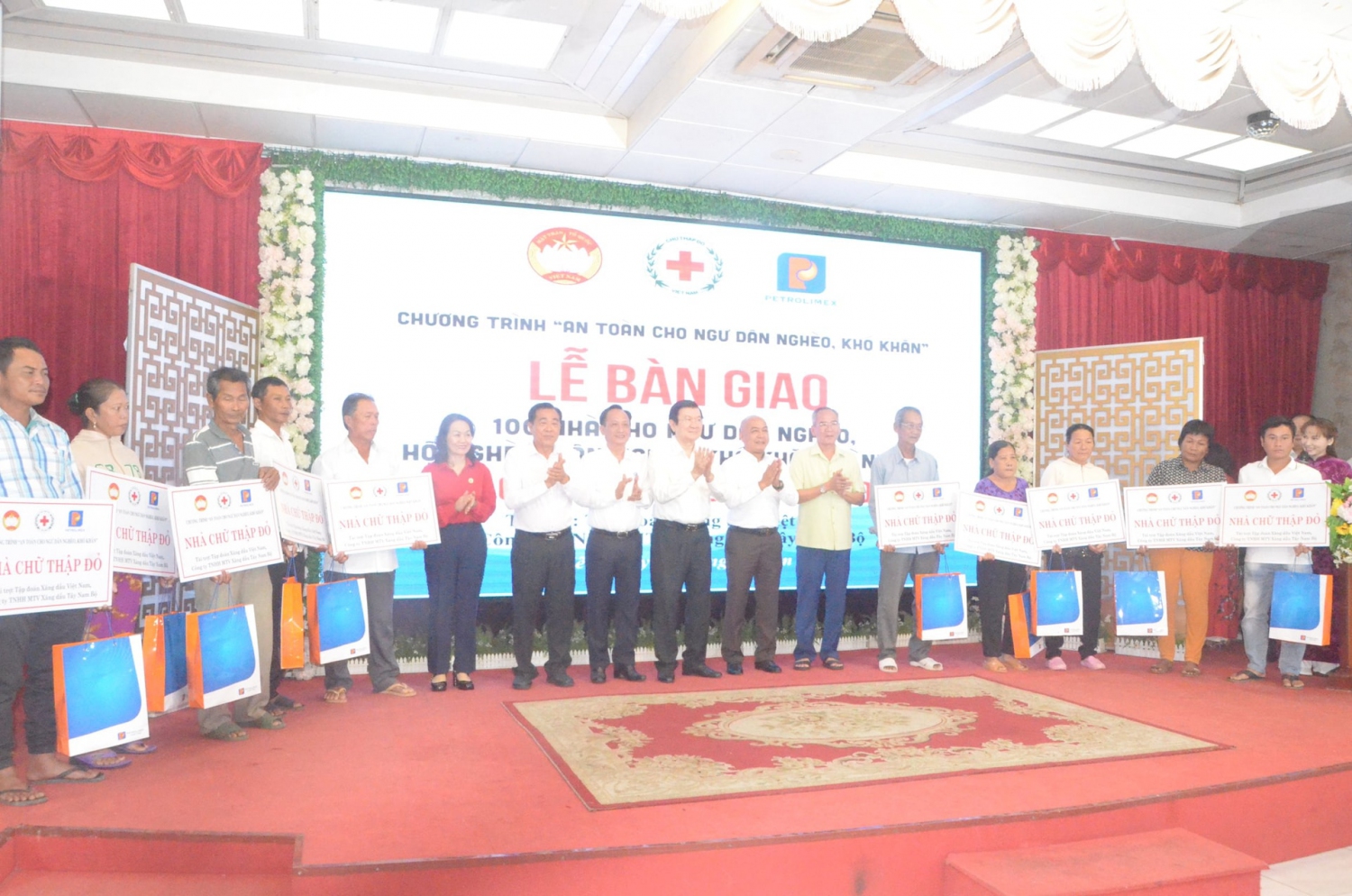 Nguyên Chủ tịch nước Trương Tấn Sang, lãnh đạo Trung ương Hội chữ thập đỏ Việt Nam và lãnh đạo tỉnh Bạc Liêu trao bảng tượng trưng bàn giao nhà cho các ngư dân nghèo, khó khăn trên địa bàn thành phố Bạc Liêu. Ảnh: Nguyên Du