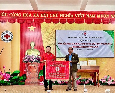 Ông Hà Văn Cát - Chủ tịch Hội CTĐ tỉnh (phải) tặng cờ thi đua xuất sắc cho Hội CTĐ TP Quy Nhơn