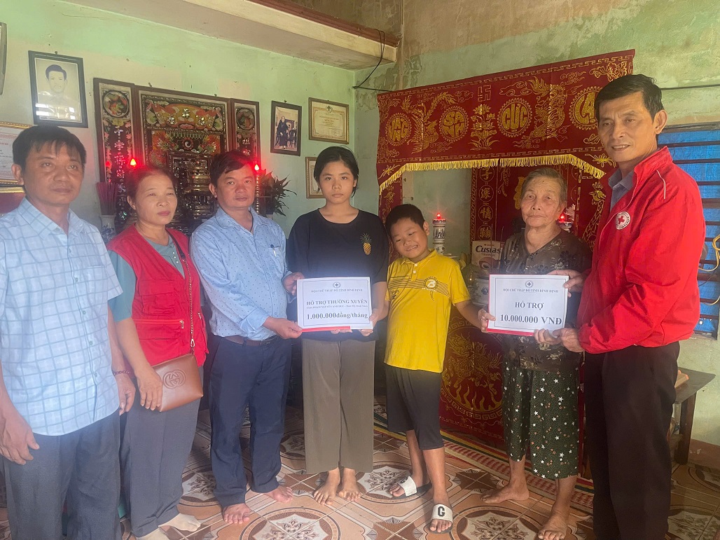 Ông Lê Phong - Phó Chủ tịch thường trực tỉnh Hội (bên phải) trao tiền hỗ trợ cho cháu Duy
